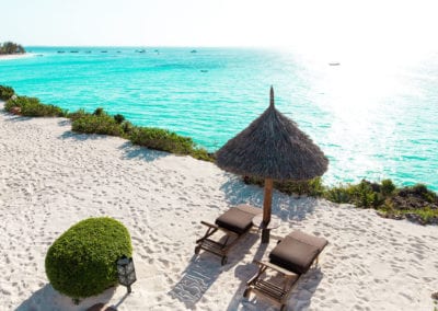 Flight Centre Zanzibar private hotel beach with loungers and umbrella